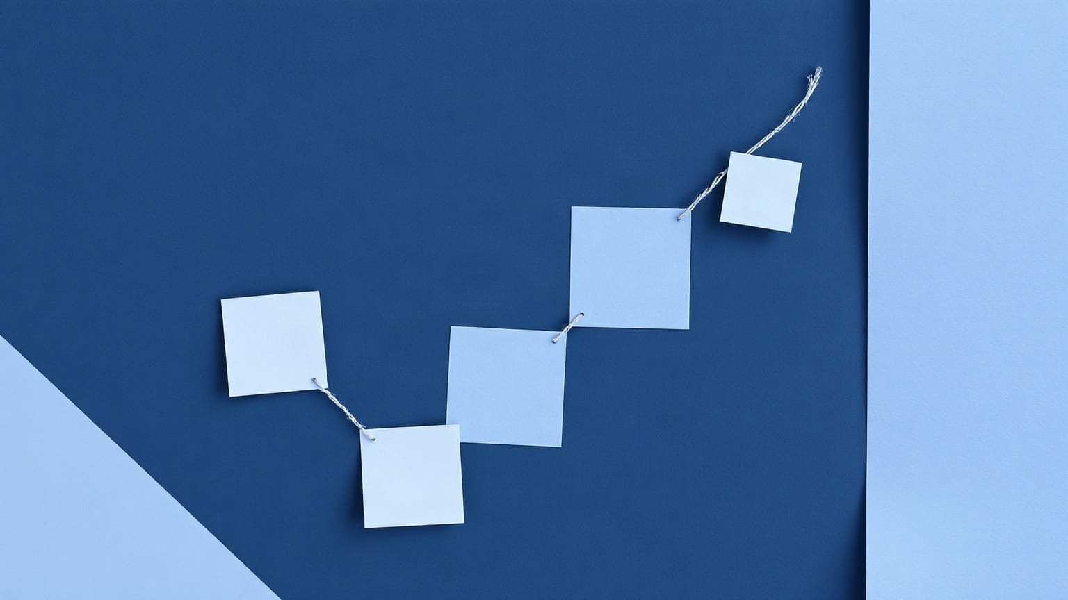 A grid of small periwinkle paper squares on an indigo ground, a few of them lifted forward and joined by pale lilac threads