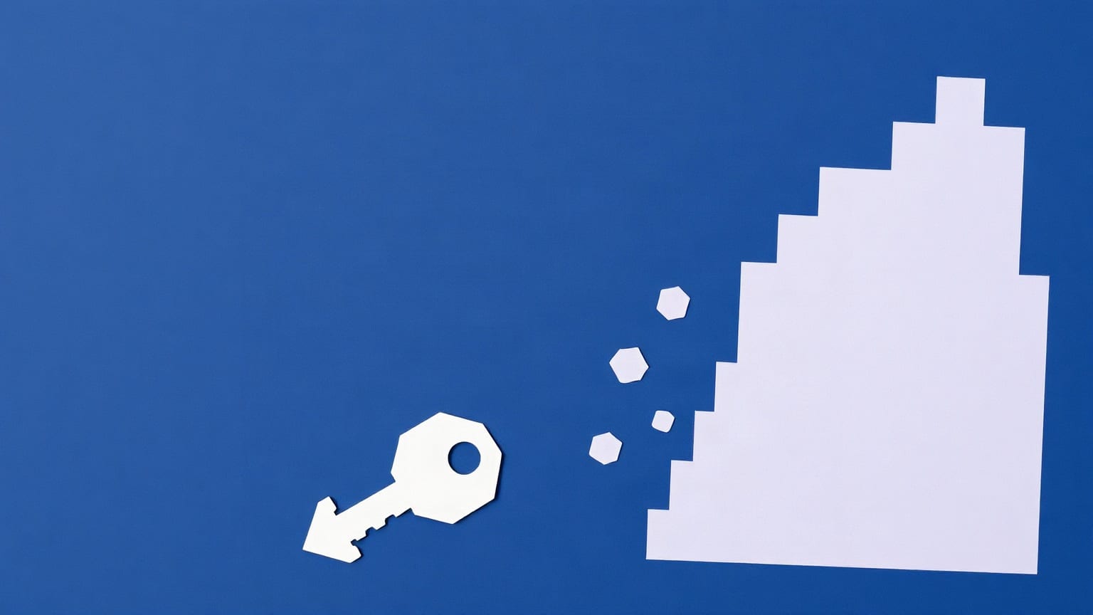 A paper tower breaking apart at one edge into small hexagon tiles, with a key below