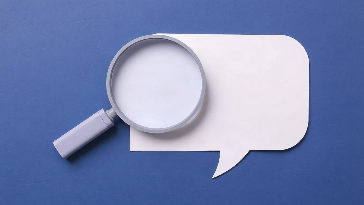 A paper magnifying glass overlapping a paper speech bubble of similar size